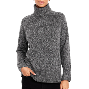 A person is wearing a gray turtleneck sweater with a textured knit and ribbed cuffs, paired with black pants.