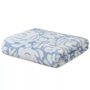 A folded blue and white blanket with a floral pattern.