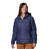 A woman is wearing a hooded Columbia jacket in navy blue with the brand's logo on the left chest, featuring a zip front and side pockets.