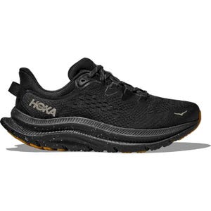 A black Hoka trail running shoe with a textured mesh upper, thick cushioned sole, and speckled midsole, designed for stability and comfort on rough terrains.