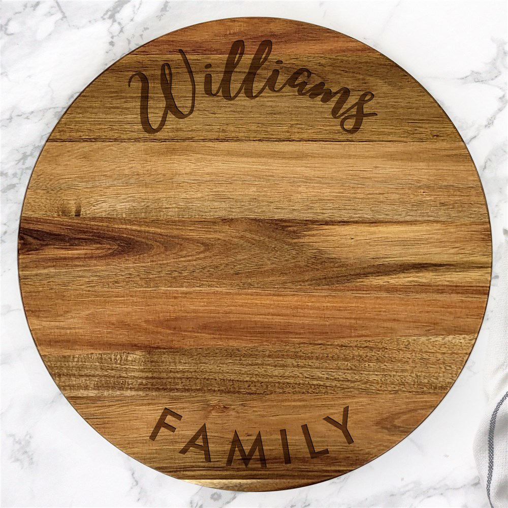 Round wooden cutting board with engraved text \“Williams Family,\“ suitable for personalized kitchen decor.