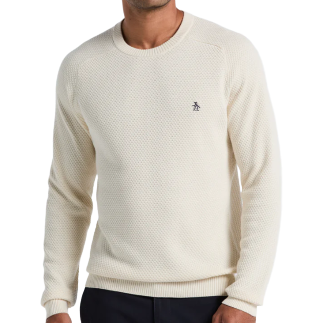 Cream-colored waffle knit sweater with a small penguin logo on the left chest, featuring a round neckline and long sleeves.
