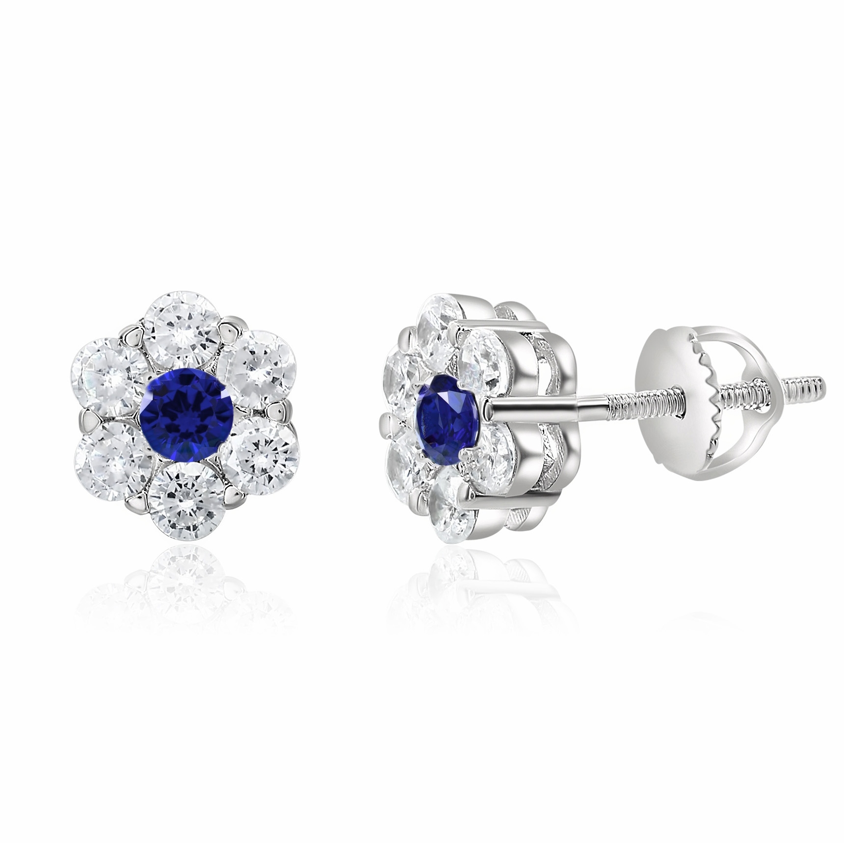 Silver stud earrings with a flower design feature a blue center stone, resembling a sapphire, surrounded by smaller clear stones, resembling diamonds.