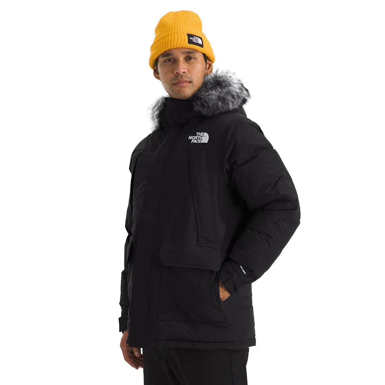 A person is wearing a black The North Face parka with a fur-trimmed hood and a yellow beanie.