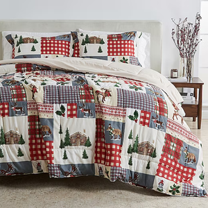 A patchwork quilt set featuring rustic designs with cabins, animals, and plaid patterns in red, blue, and beige tones; includes a comforter and matching pillow shams.