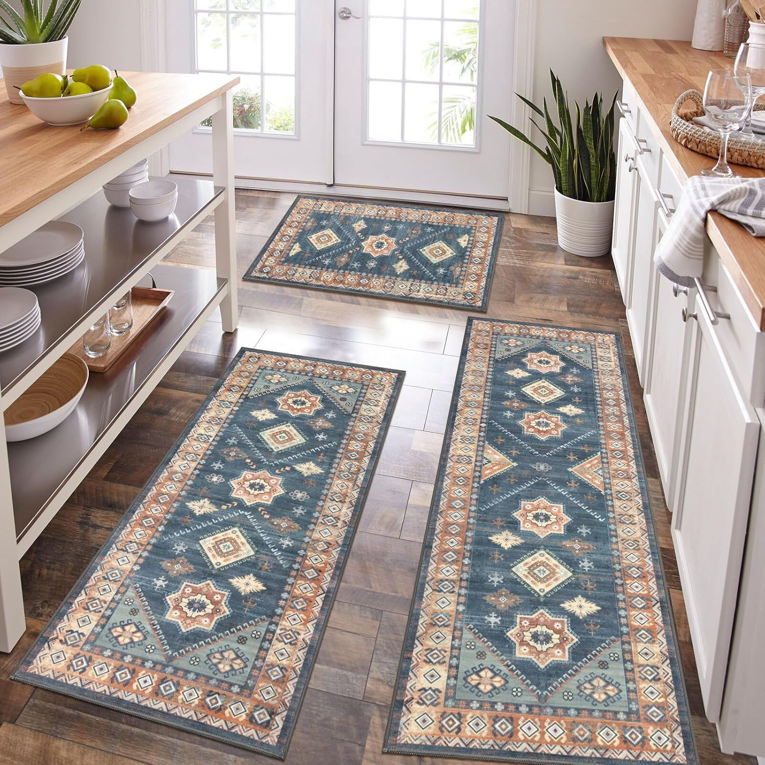 3-piece kitchen rug set featuring a southwestern geometric pattern in blue, beige, and rust colors on a dark wood floor. Includes a small mat, and two long runners placed near countertops and a kitchen island.