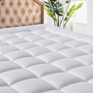 A white, quilted cooling deep-pocket mattress topper with a subtle checkered pattern, designed for comfort and breathability. It is shown on a bed with an elegant tufted headboard and accompanied by a potted plant.