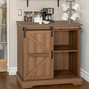 Wooden cabinet with a sliding barn door houses shelves on one side; coffee maker, jars, and a mug tree stand on top.