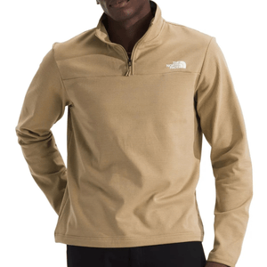 A beige quarter-zip pullover by The North Face, featuring a high collar and logo on the chest, worn by a person with hands on hips.