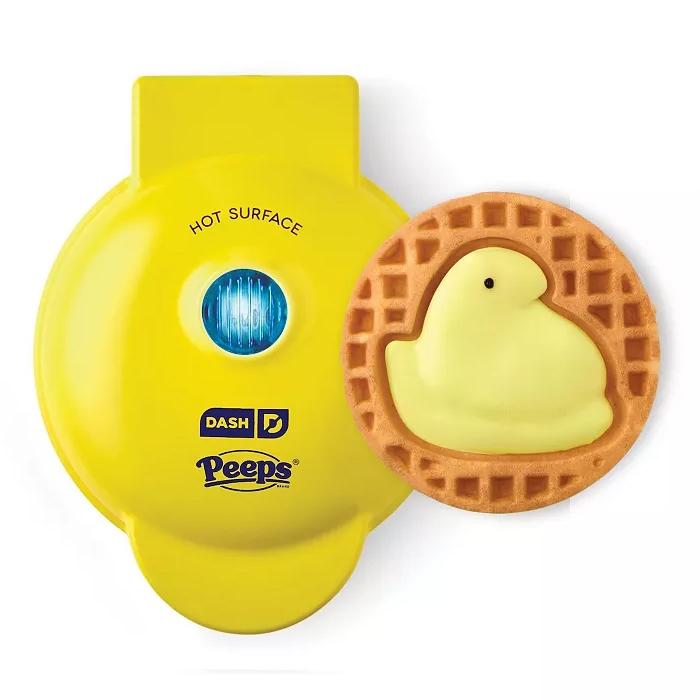A yellow Dash waffle maker with Peeps branding sits next to a waffle featuring a chick design.