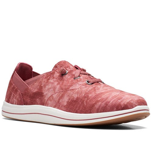 Clarks Breeze Flats are casual women's shoes featuring a red tie-dye pattern, with lace-up detail, elastic back, and white rubber sole, offering a blend of comfort and style.