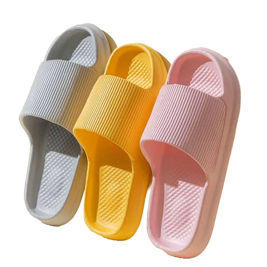Three pairs of slide sandals in gray, yellow, and pink with a ribbed strap design and textured footbed.