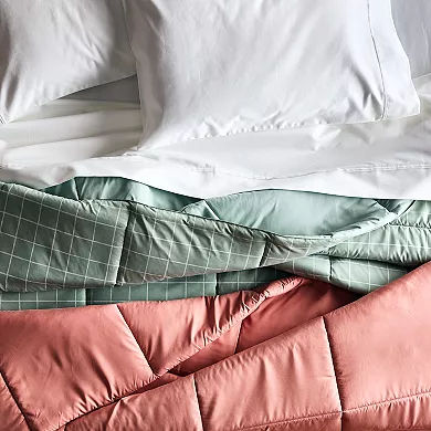 Two down-alternative comforters are shown, one in a solid mint green and the other in a peach color with a grid pattern.