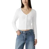 A woman wears a white ribbed V-neck button-up long-sleeve top paired with blue high-waisted wide-leg jeans that feature a tie belt.