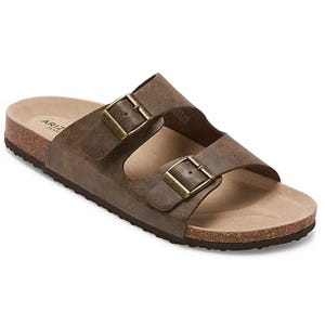 Brown slide sandals with two adjustable buckle straps and a cork-like sole, designed for comfort with a flat, cushioned footbed.