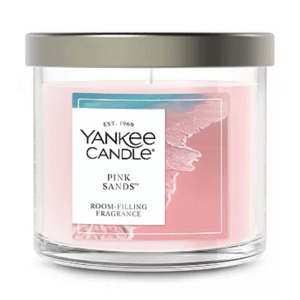 Yankee Candle Pink Sands, a room-filling fragrance in a glass jar with a metal lid. The candle wax is pink, featuring a beach-themed label.