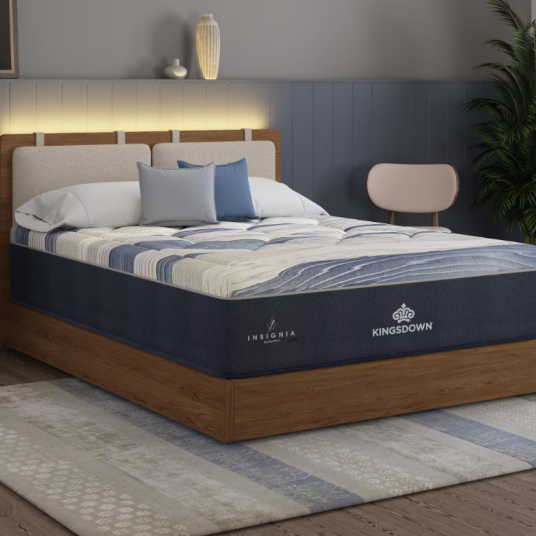 Kingsdown Insignia Collection mattress on a wooden platform bed with blue and white bedding, accented by pillows and ambient lighting, in a modern bedroom setting.
