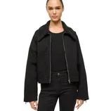 A person is wearing a black jacket with a sherpa collar over a black ribbed shirt and matching black pants.