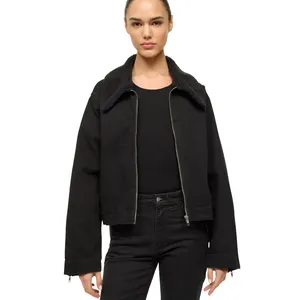 A person is wearing a black jacket with a sherpa collar over a black ribbed shirt and matching black pants.