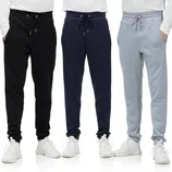Three pairs of men's jogger sweatpants in black, navy, and gray, each featuring a drawstring waistband and pockets. They are worn with white sneakers and white long-sleeve shirts.