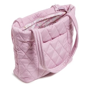 Light pink, quilted tote bag with a floral-patterned inner lining, featuring two fabric handles and a spacious design for practical use.