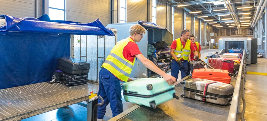 airport employees sorting baggage