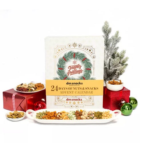 a variety of nuts in front of a white box and a spruce tree