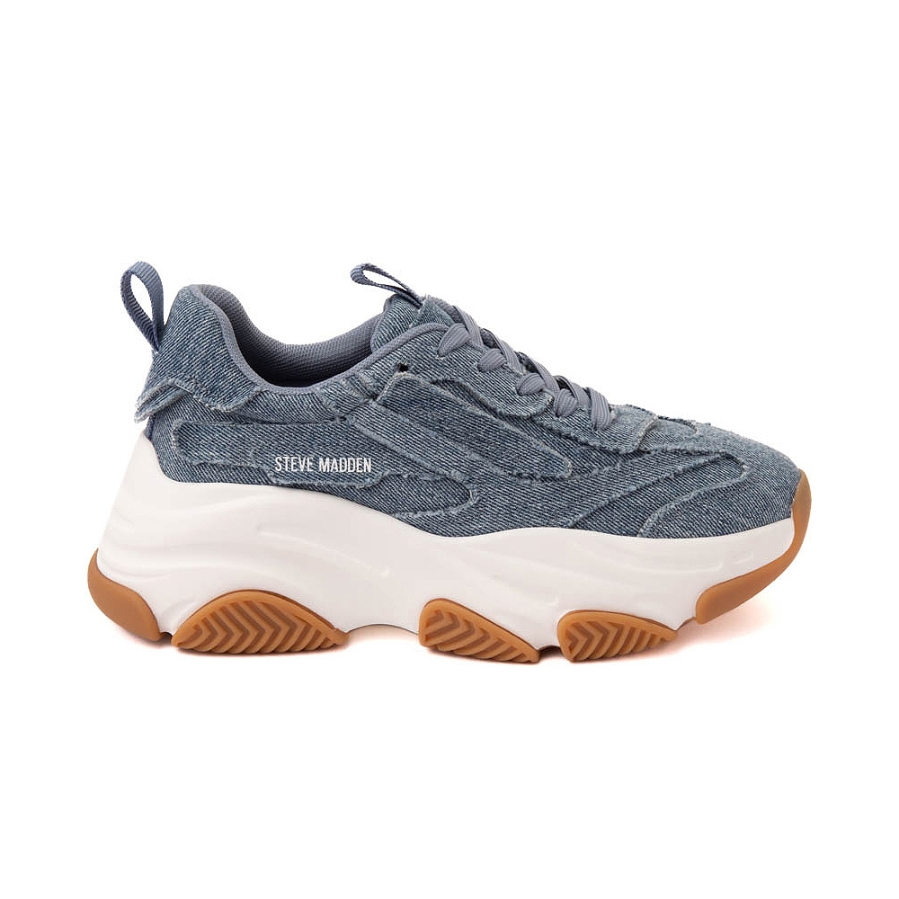 Blue denim-textured sneakers with a chunky white sole and brown rubber accents designed by Steve Madden, featuring laces and a subtle brand logo on the side.