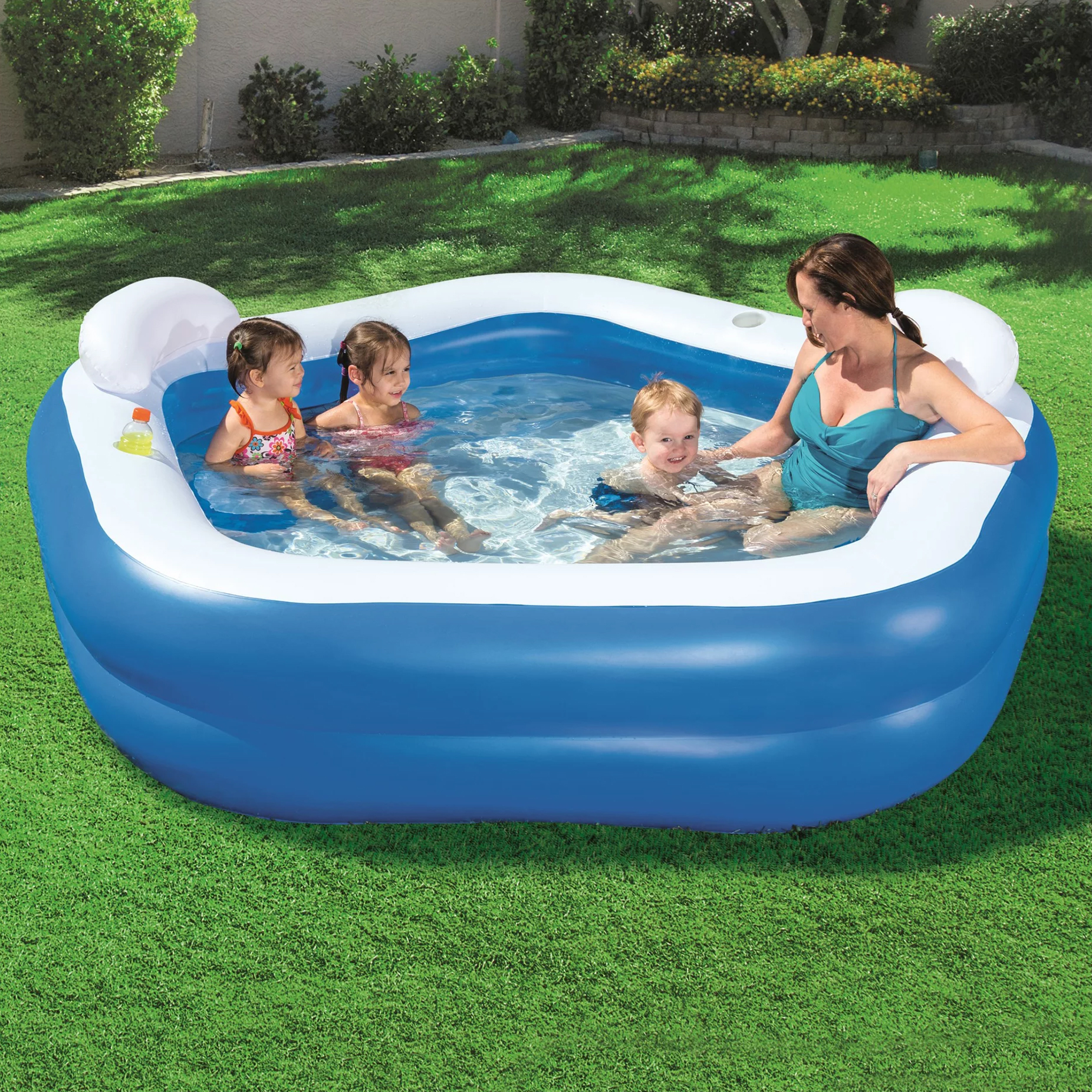 An inflatable kiddie pool with three children and an adult inside.