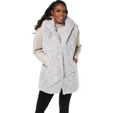 A person is wearing a light gray faux fur vest with a large collar, over a beige knit sweater and black leggings.