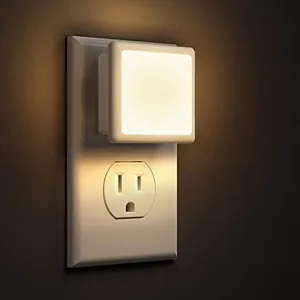 A plug-in night light with a square, soft-glow design attached to a wall outlet, suitable for ambient lighting.
