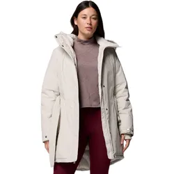 A woman is wearing a light-colored winter coat with a high collar over a mauve turtleneck and maroon leggings.