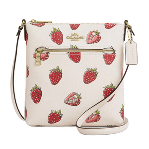 The Coach Outlet Rowan Crossbody features a playful strawberry print on a white background, with a gold zipper pocket, Coach logo, and a detachable tag. The bag includes an adjustable strap for easy carrying.