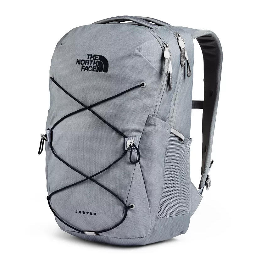 This is a light gray The North Face Jester backpack featuring a flexible bungee cord system on the front, multiple zippered compartments, and breathable mesh panels on the shoulder straps and back.