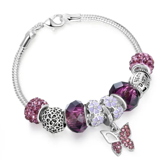 Silver charm bracelet featuring purple and lavender beads, including textured and faceted designs with a butterfly pendant.