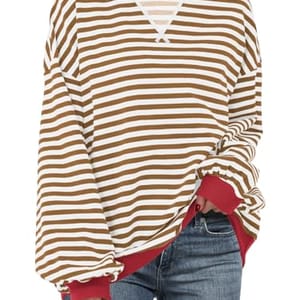 A striped oversized sweatshirt with a combination of brown and white horizontal stripes and red detailing at the collar and cuffs.