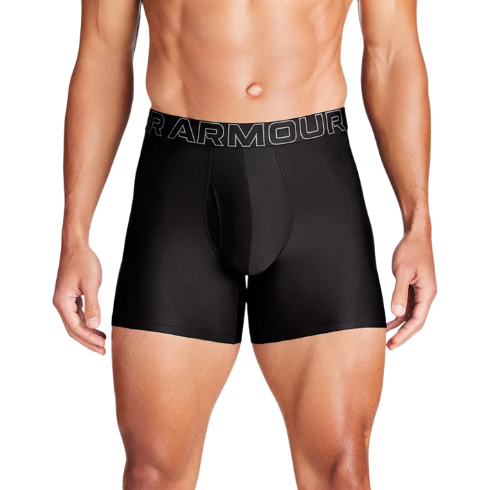 A model is wearing black Under Armour boxer briefs with prominent branding on the waistband.
