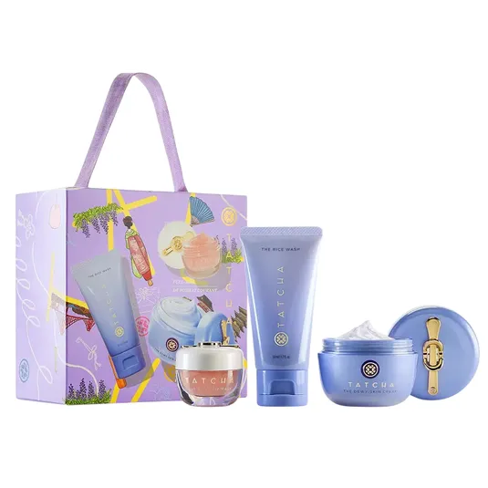 Tatcha gift set includes The Rice Wash, Dewy Skin Cream, and Kissu Lip Mask, packaged in a decorative box with a purple handle.