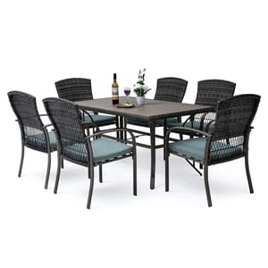 Outdoor dining furniture set with a rectangular table, six wicker chairs with blue cushions, and a bottle with two glasses on the table.