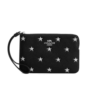 A black Coach Outlet wristlet featuring an embossed star pattern with silver stars, a zipper closure, and a wrist strap.