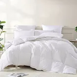 A plush white comforter filled with goose feathers, featuring a quilted design and accompanied by matching white pillows, offers a cozy and luxurious bedding setup.