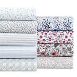 A collection of bed sheets in various patterns, including polka dots, stripes, floral designs, and geometric prints, in colors like blue, red, and gray.