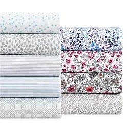 A collection of bed sheets in various patterns, including polka dots, stripes, floral designs, and geometric prints, in colors like blue, red, and gray.