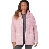 A woman wears a cozy pink, sherpa-lined jacket with front pockets over gray leggings.