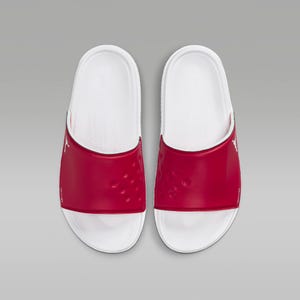 A pair of red and white slide sandals with a contoured footbed and logo detail.