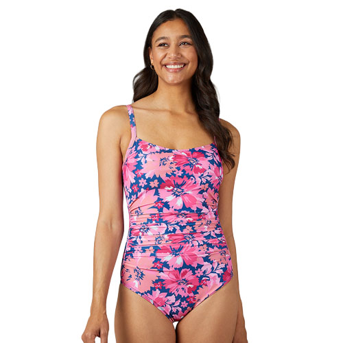 Woman wearing a pink and navy floral one-piece swimsuit with ruched detailing and adjustable straps.