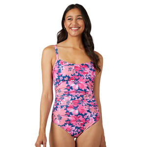 Woman wearing a pink and navy floral one-piece swimsuit with ruched detailing and adjustable straps.