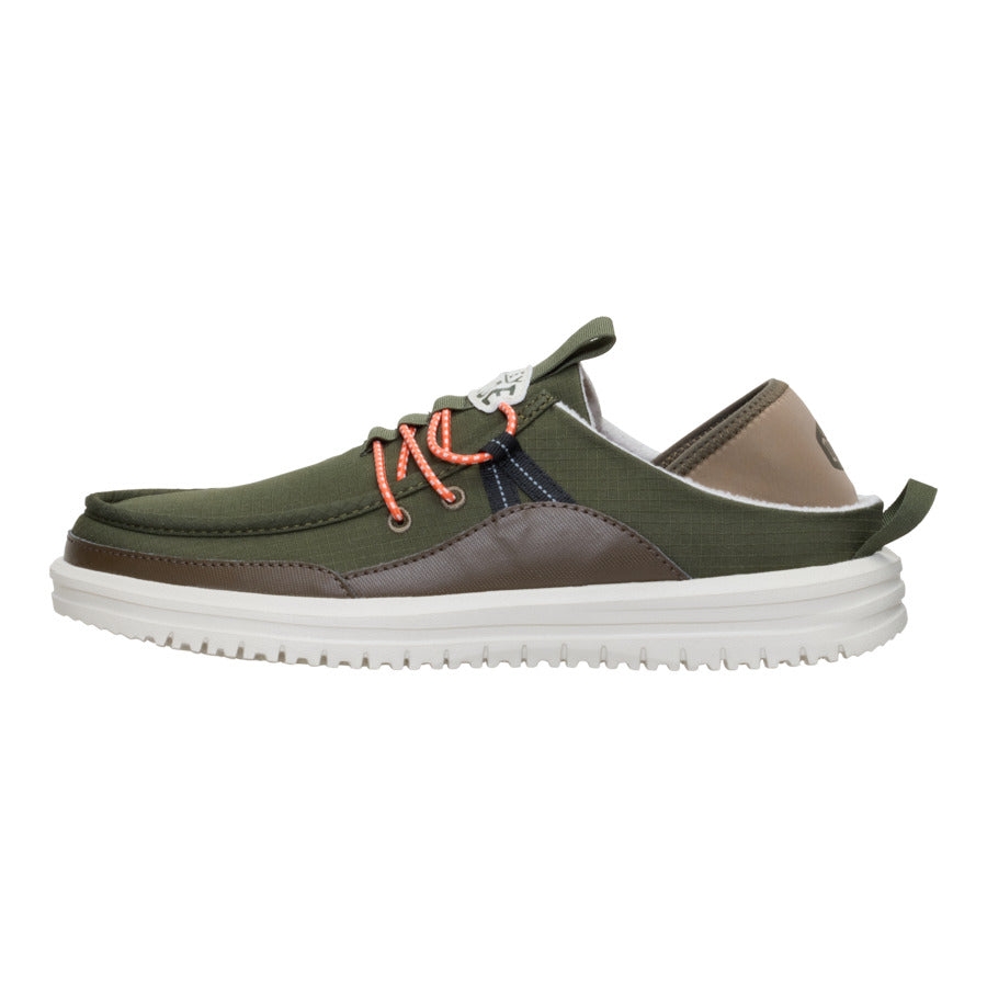 A low-cut casual shoe with an olive green fabric upper, brown accents, orange laces, white sole, and pull tab at the heel.