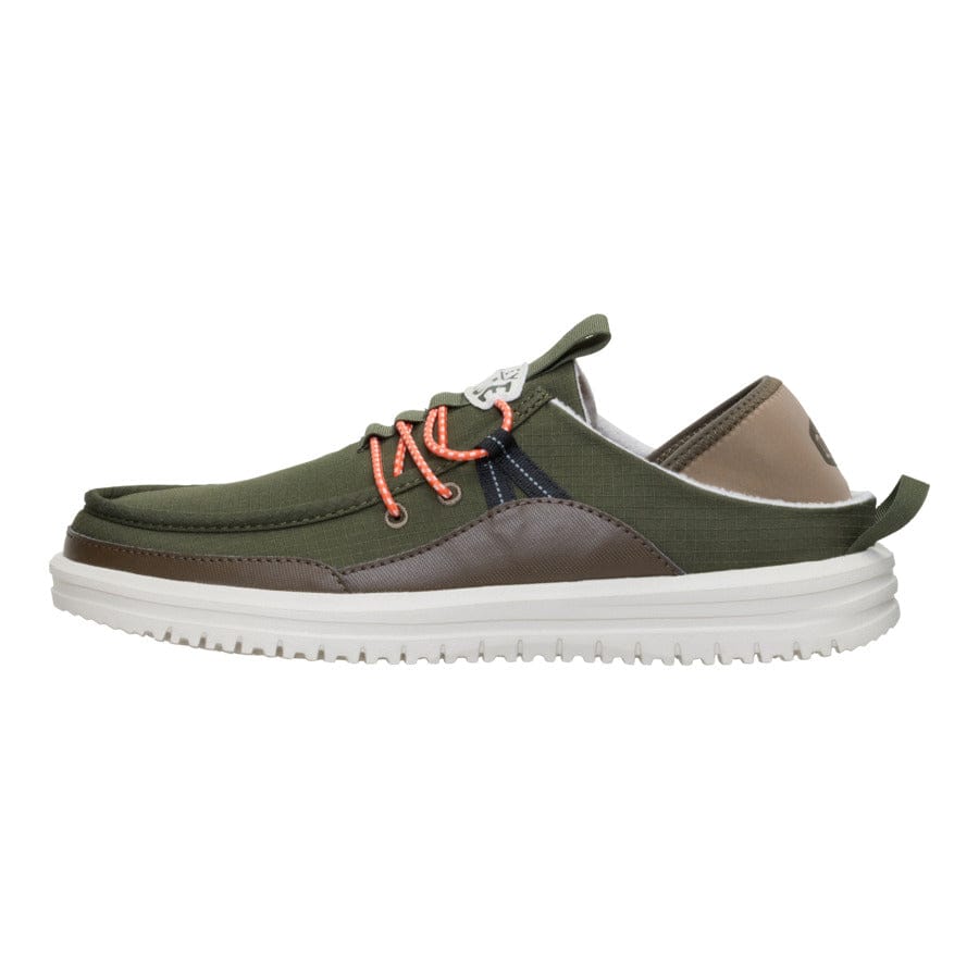 A low-cut casual shoe with an olive green fabric upper, brown accents, orange laces, white sole, and pull tab at the heel.