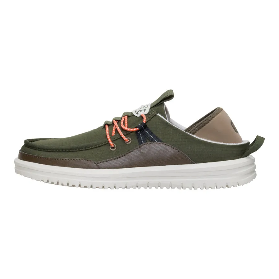 A low-cut casual shoe with an olive green fabric upper, brown accents, orange laces, white sole, and pull tab at the heel.